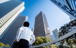 ビジネスマンビルを見上げる